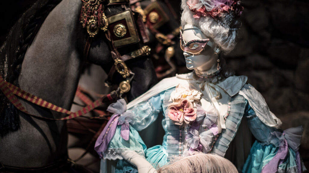 Venetian-style masked female mannequin in a pale blue eighteenth-century costume standing beside a decorated black horse, from Livrustkammaren’s I Love You Madly exhibition about Axel von Fersen and Marie Antoinette.