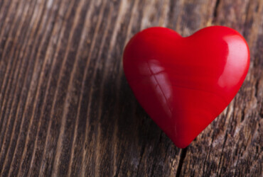Red candy heart lying on a rustic wood plank