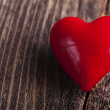 Red candy heart lying on a rustic wood plank
